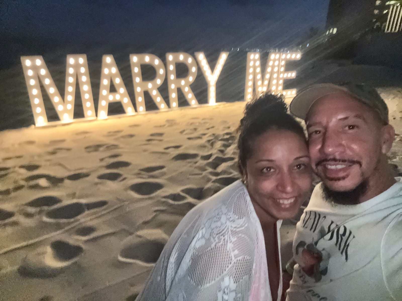 'Marry me' written on the beach